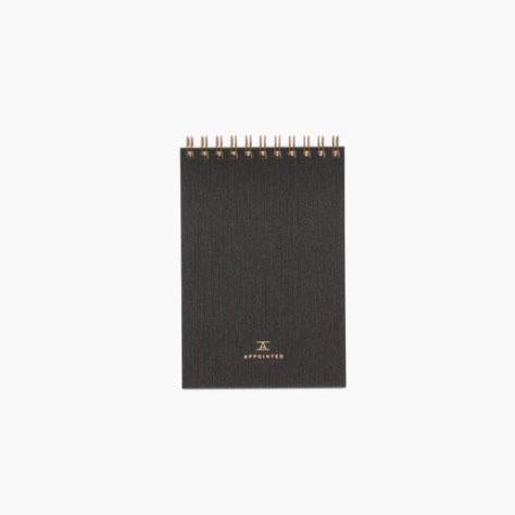 Charcoal gray office notepad, "A/Appointed" printed on bottom, with gold/tan lettering. Gold loop binding.