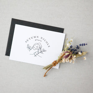 White card with client logo, dark gray envelope, floral bundle with lavender and white flowers