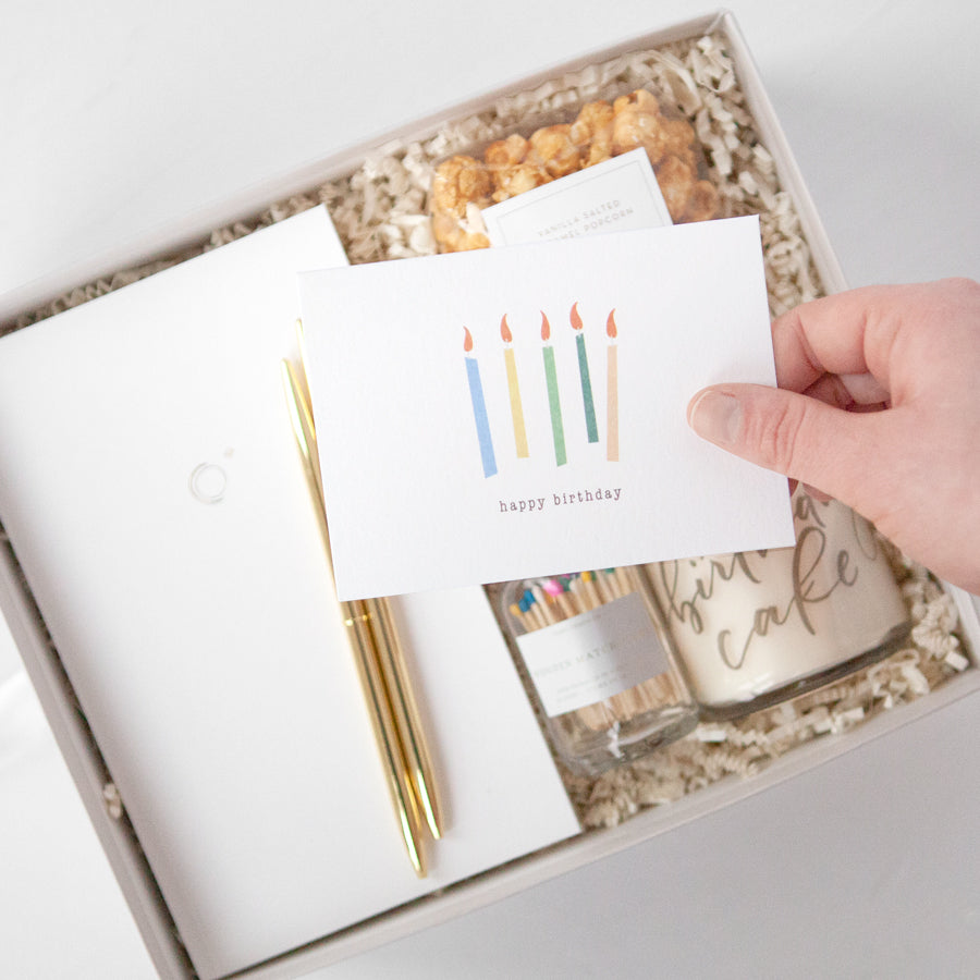 White card that reads "happy birthday" underneath five multicolored candle illustrations