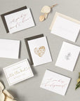 Seven car options, and floral bundles/flower stems. some read, "will you be my maid of honor?", "Congrats", "I couldn't tie the knot without you", "thank you", and will you be my bridesmaid?". Others have a golden heart and floral graphics. A few paired with envelope color options: slate gray or ivory shimmer.