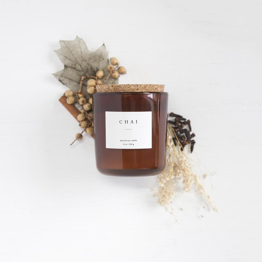 8 oz chai scented soy candle, approx 3.25&quot; x 3.75&quot;, brown glass container with cork lid and white sticker. Pictured with dried autumn themed florals