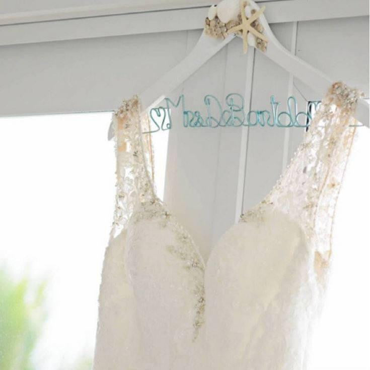 Wedding dress hanging on white seashell and starfish hanger with blue handcrafted wire name