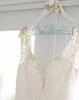 Wedding dress hanging on white seashell and starfish hanger with blue handcrafted wire name