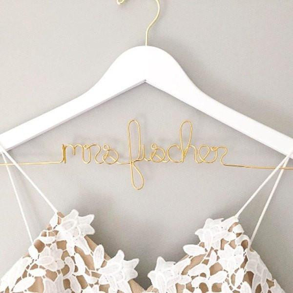 Personalized white hanger with gold hook. Gold wire base shaped into personalized name.