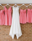 Wedding dress and bridesmaid dresses hung on custom white hangers with base wires shaped into names