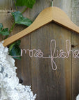 Light brown wooden hanger with custom base wire shaped into name