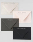 Four envelopes. Ivory shimmer, Luxe Blush, Slate gray, and Matte Black