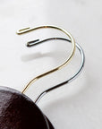 Two dark wooden hangers, gold and silver hooks