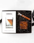 Corkcicle whiskey wedge box, clear plastic cube of bourbon bears and brown glass vial of Daneson  scotch infused toothpicks arranged in a black box with black paper shred.