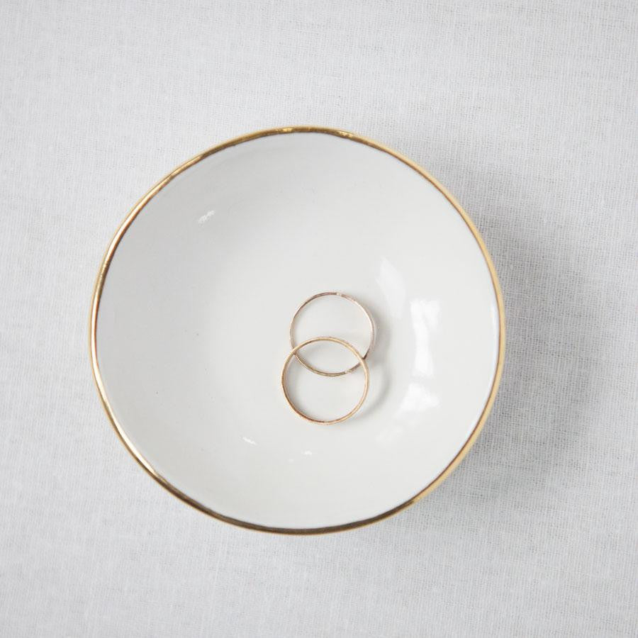 Gilt rim white ring dish containing two rings