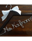 Dark wooden hanger with satin bow and silver hook. Personalized base wire shaped into name